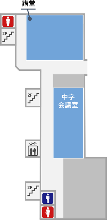 講堂の隣に女子トイレがあります。講堂の反対側の奥には男子トイレと女子トイレがあります。講堂の前の廊下は本館２階と渡り廊下で繋がっています。
